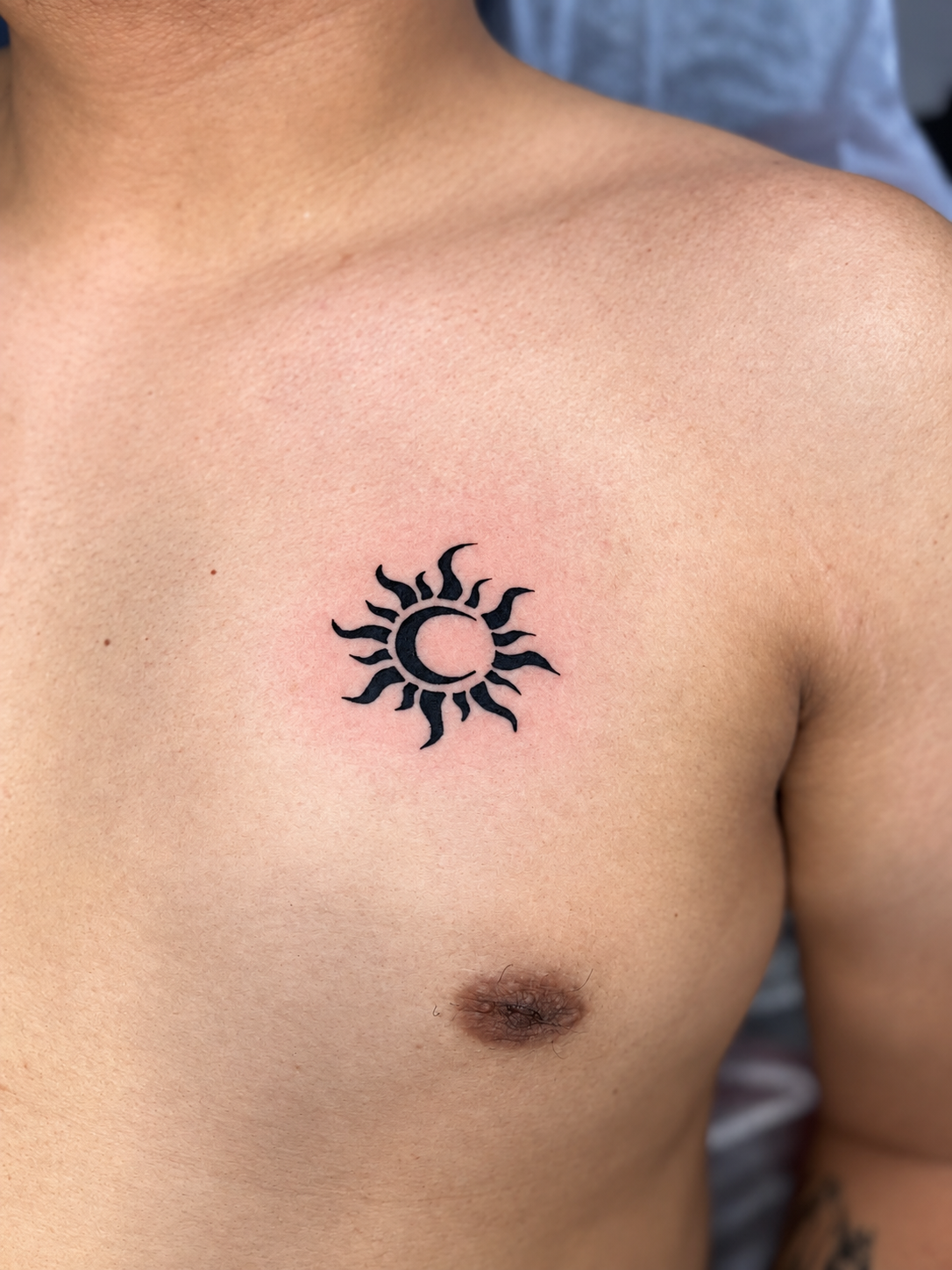 Tatouage Blackwork d’un soleil sur la poitrine