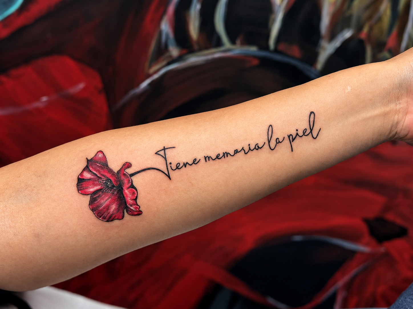 Tatouage lettering accompagné d’une fleur rouge