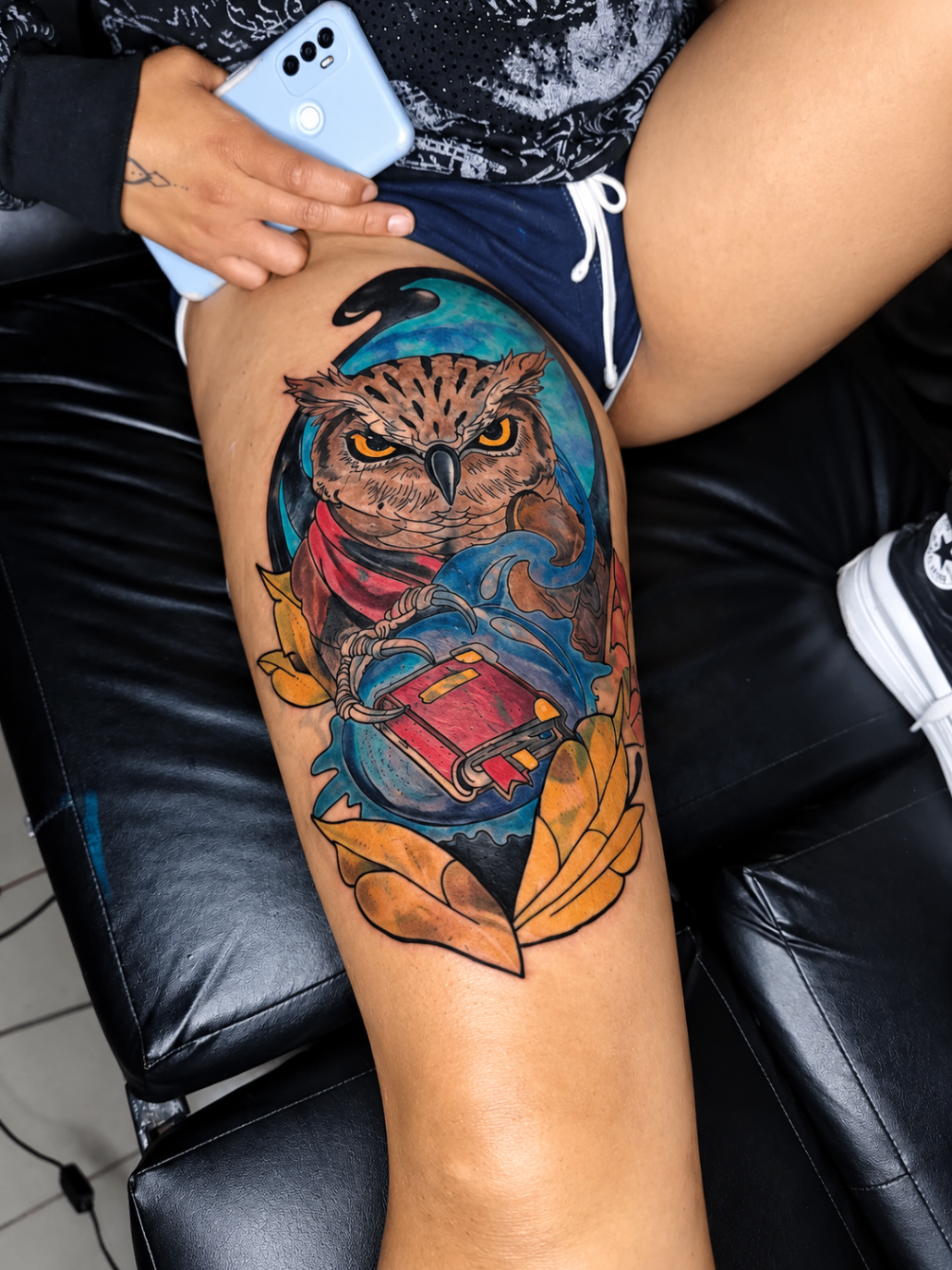 Tatouage néo-traditionnel d’un hibou posé sur un livre