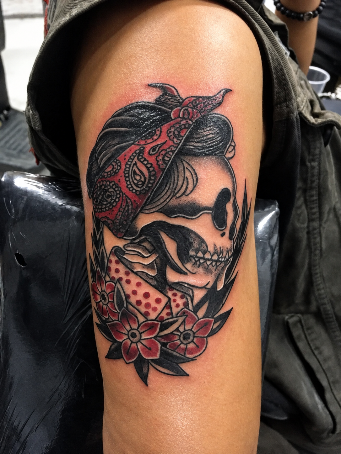 Tatouage neo-traditional représentant une tête de mort au foulard rouge