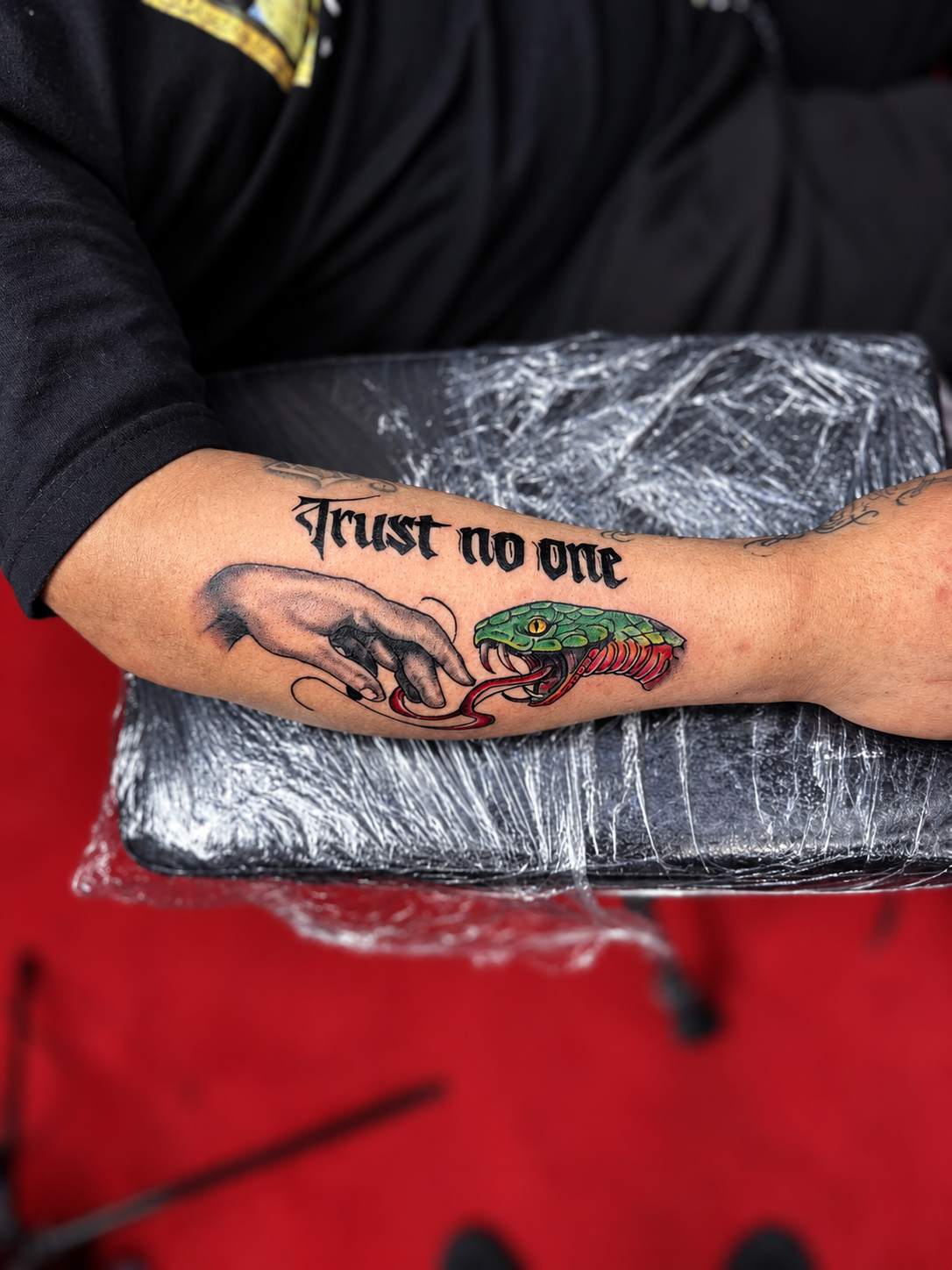 Tatouage Trust no one avec une main et un serpent coloré