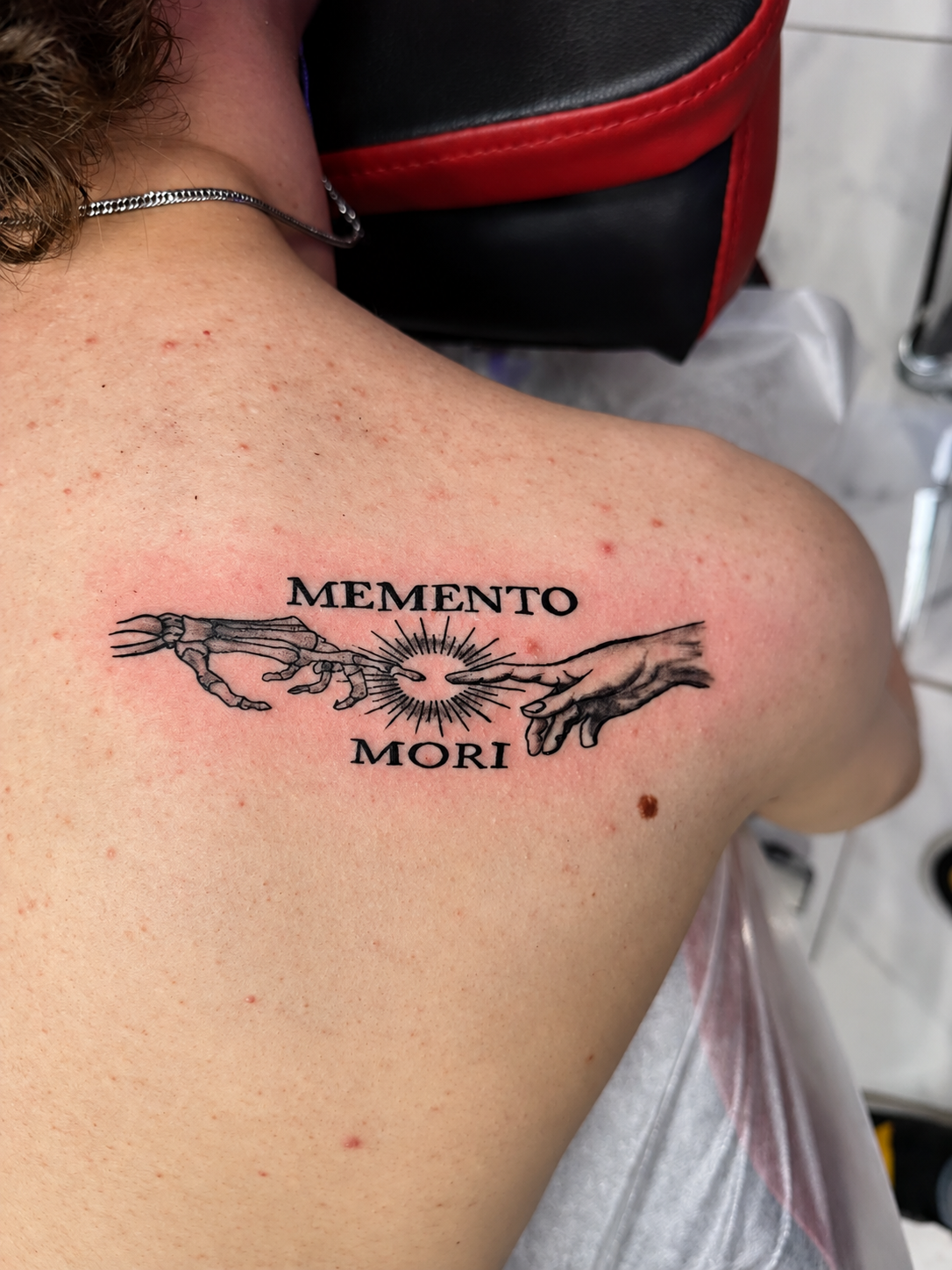 Tatouage Memento Mori avec mains et soleil sur le dos